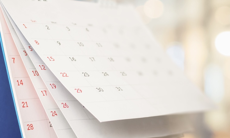 Close up white paper desk calendar with blurred bokeh background appointment and business meeting concept