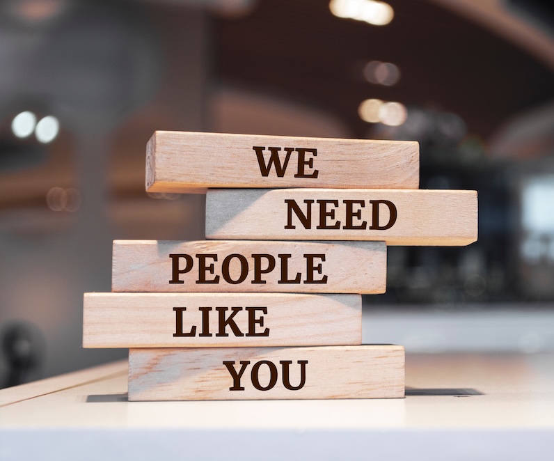 Wooden blocks with words 'We Need People Like You'.