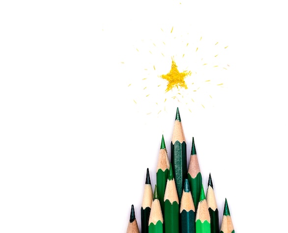 A creative Christmas tree made of green pencils on a white background, a yellow star made of shavings on the top.Christmas and New Year flat lay.